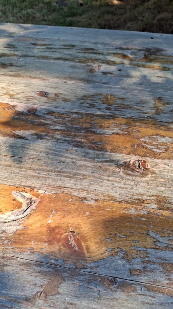 particolare tavolo da giardino in legno rovinato da rinnovare